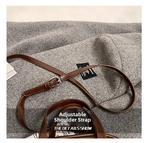 Detail eines verstellbaren Leder-Schultergurts mit silberner Metallschnalle an brauner Tasche