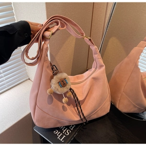 Pink suede hobo bag with adjustable strap and cute plush sheep pendant detail