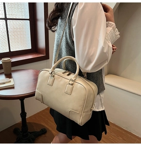 Chic cream leather Boston bag styled in a cozy cafe setting for daily outfit inspiration