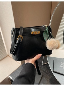 Chic black leather handbag with golden twist lock and cherry pompom charm for women
