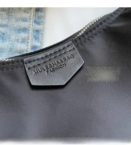 Detail of black nylon fabric texture with silver metal zipper and shield leather logo