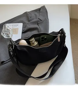 Detail of spacious interior compartment in black nylon dumpling bag for daily essentials
