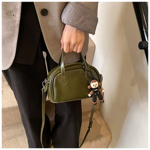 Detail der olivgrünen Bowling-Tasche aus Leder mit Anhänger und Schultergurt