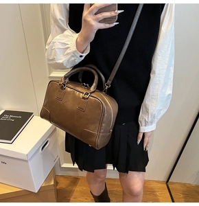 Brown Boston handbag in a chic mirror selfie showing stylish crossbody wear and logo detail