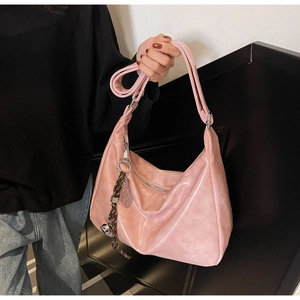 Detail of pink glossy hobo bag with silver zipper and tennis racket charm accessory