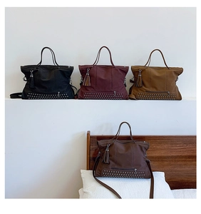 Close-up of vintage tote bags with metallic rivets and stylish tassel charms in four colors
