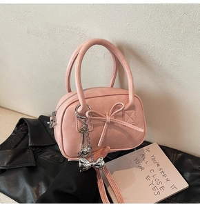 Dettaglio borsa bowling in pelle opaca rosa con fiocco 3D e ciondolo in argento