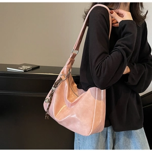 Close-up of pink patent leather tote bag with glossy finish and decorative knotted tassel