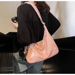 Pink faux leather tote bag with silver tennis racket charm and adjustable shoulder strap