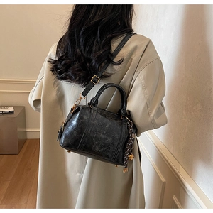 Detail of black vintage textured PU leather crossbody bag with embossed SAL lettering