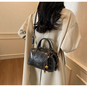 Detail view of black vintage Boston bag featuring CULTIVATOR embossing and gold hardware