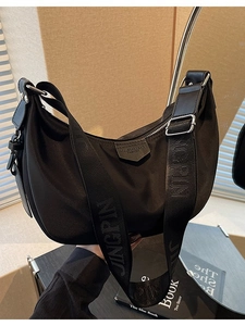 Fashionable black nylon hobo bag with adjustable branded strap and silver zipper closure