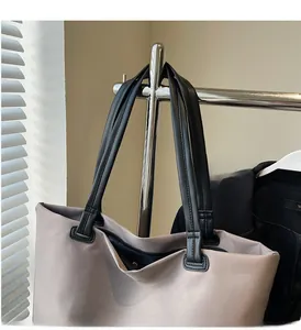 Détail des poignées en cuir noir renforcé et fermeture éclair du grand sac de voyage