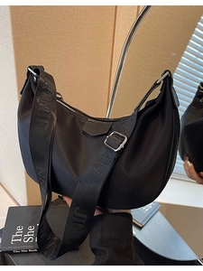 Fashionable black nylon half-moon crossbody bag with wide embossed strap and silver buckles