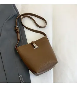 Detail of dark brown lychee leather bucket bag with silver metal swivel lock closure
