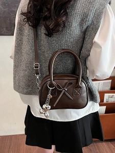 Borsa bowling vintage marrone scuro con fiocco in pelle e ciondolo a cuore a tracolla