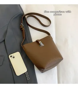 Litchi pattern bucket bag size comparison with smartphone showing practical capacity