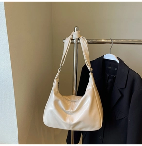 Detail of hobo shoulder bag with glossy cream finish and knotted strap design