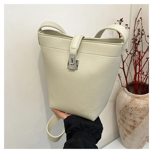 Detail of lychee pattern leather bucket bag with silver metal swivel lock and strap