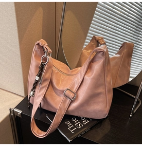Detail of light pink tote bag with pleated leather texture and silver buckle strap
