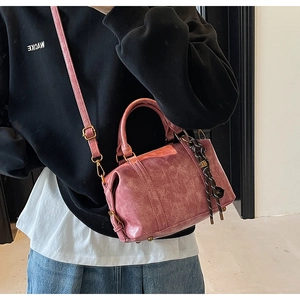 Pink Boston bag close-up showing vintage marble texture and woven ball charm detail