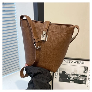 Close-up of brown litchi pattern leather bucket bag with silver buckle detail