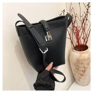 Detail of lychee pattern leather bucket bag with silver metal twist lock closure