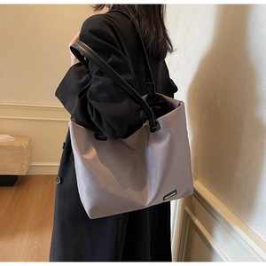 Détail du grand sac de voyage taupe avec poignées en cuir noir de haute qualité