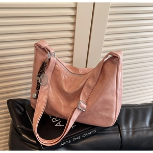 Detail view of pink glossy Hobo bag with silver hardware and tennis racket charm