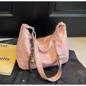 Detailed close-up of a pink PU leather tote bag with woven rope charm and zipper closure