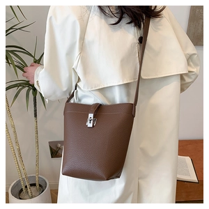 Close-up of brown litchi pattern leather bucket bag with silver metal swivel lock