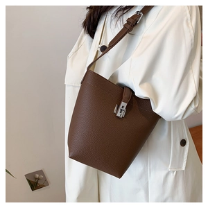 Detail of lychee pattern leather bucket bag featuring a silver metal lock and strap