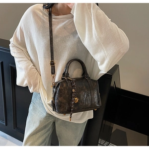 Detail of vintage embossed leather handbag with adjustable shoulder strap and gold hardware