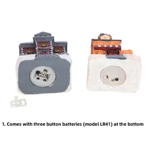Detail view of miniature house base showing LR41 button battery compartment and insulation tab