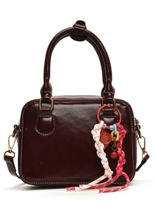 Deep burgundy Boston leather handbag with white contrast stitching and tassel charm