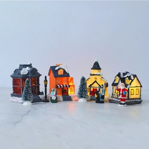 Macro shot of LED glowing Christmas village house set with miniature snowy pine trees