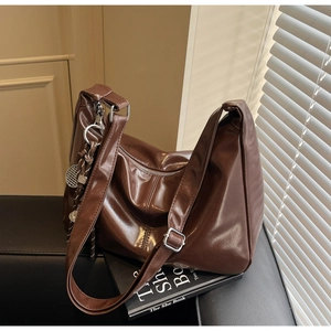 Detail of dark brown glossy leather Hobo bag with silver hardware and mesh charm