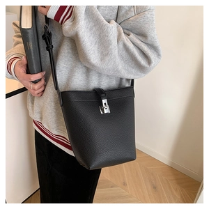 Detailed view of black lychee grain bucket bag with silver hardware and leather strap