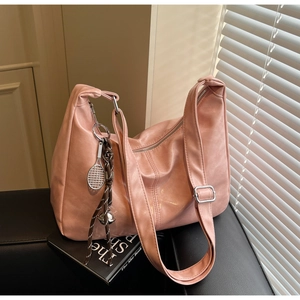 Detailed macro view of a pink soft PU leather hobo bag with a tennis racket charm detail