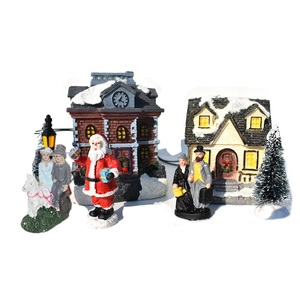 Detailed view of LED Christmas village set with snow-covered houses and resin figures