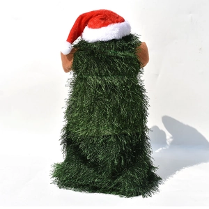 Detail of green fringe fabric Christmas tree decor with Santa hat and plush ears