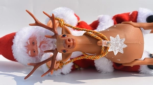 Detail view of musical Santa Claus riding reindeer ornament with golden reins and star lamp