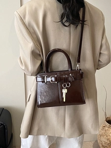 Vintage glossy chocolate brown handbag with key pendant and crossbody strap for women