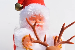 Macro detail of plush Santa Claus with golden bell and reindeer antlers Christmas decor