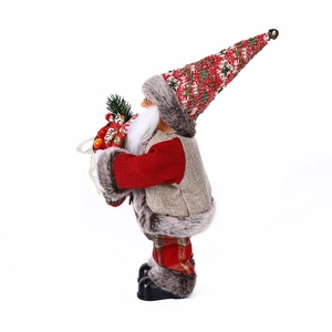 Detail of Santa Claus figure with a tall knitted hat holding a gift box and pine