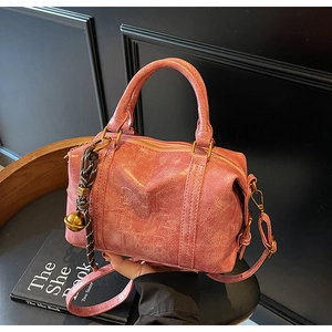 Detailed macro of pink vintage Boston bag with gold zipper and bell pendant