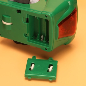 Bottom view of electric Santa toy showing battery compartment, power switch and gears