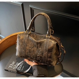 Close-up of vintage dark brown Boston bag texture and embossed lettering detail