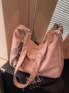 Chic pink glossy leather hobo bag with adjustable strap and tennis racket charm
