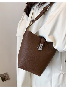 Dark brown lychee pattern leather bucket bag with silver metal buckle on a model